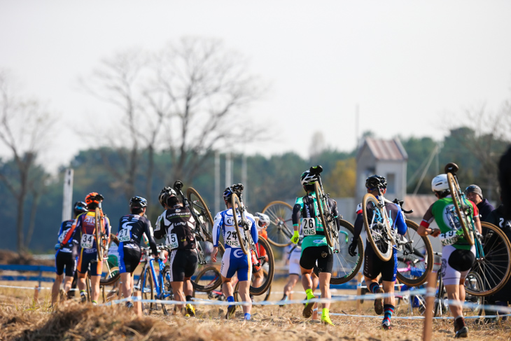 ピット前でバイクを担いで走る選手たち
