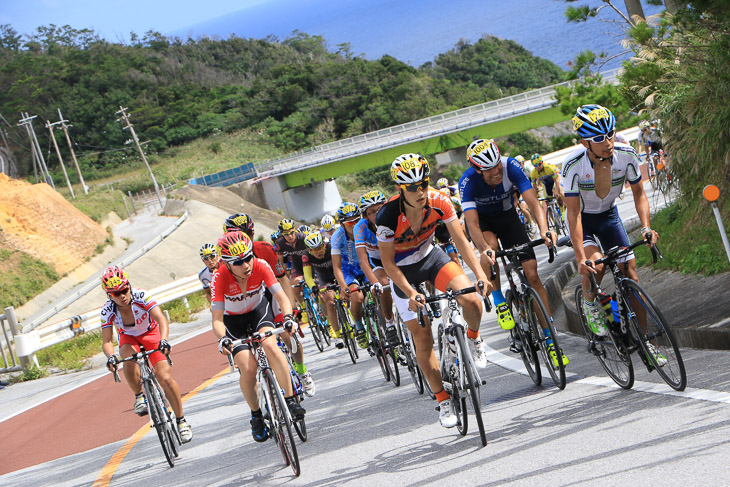 東海岸のアップダウンを行く市民140kmのメイン集団 中央に優勝した横塚 浩平(オーベスト)