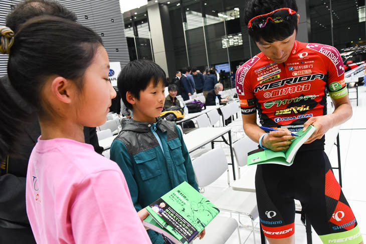 TOJキッズの2人にサインする増田成幸(宇都宮ブリッツェン)