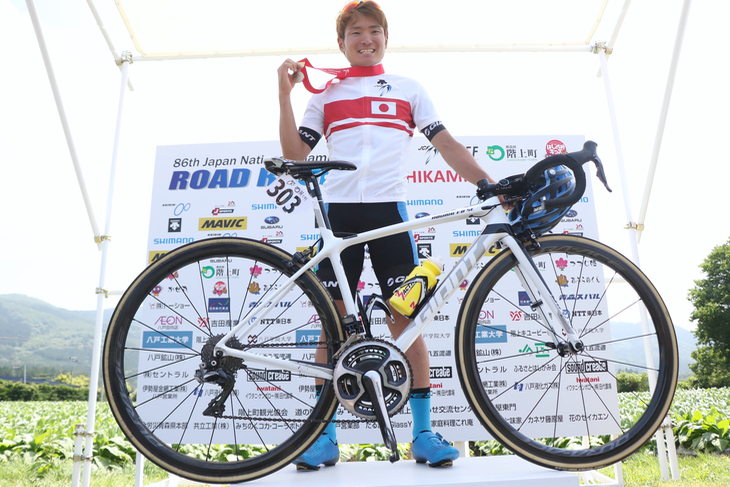 チャンピオンジャージでバイクと共に表彰台に上がる横山航太(シマノレーシング)