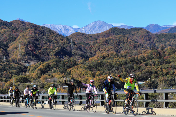 南アルプスの山々をバックに走っていく ツール・ド・富士川ステージ