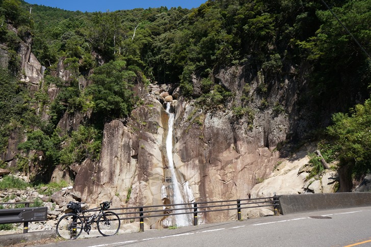 道路わきの岩壁から流れ落ちる滝に涼を求めるが暑すぎておかしくなりそう!!