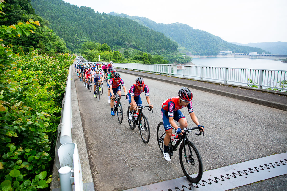 宮ヶ瀬湖畔のコースを進む集団 奥に見えるのは宮ヶ瀬ダム