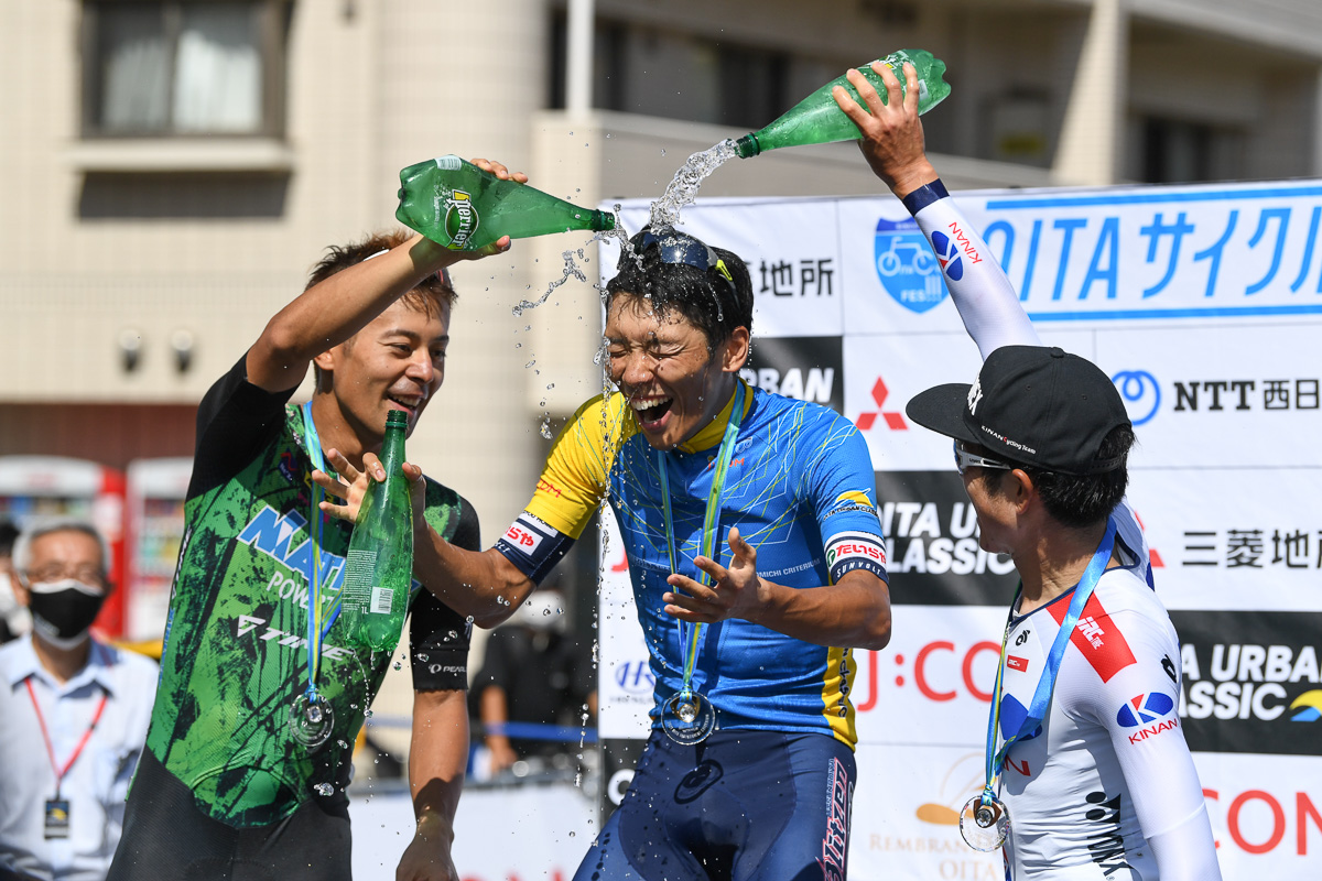 シャンパン代わりの炭酸水ファイト 2位吉田隼人(マトリックスパワータグ)と、3位中島康晴(キナンサイクリングチーム)から手荒な祝福を受ける