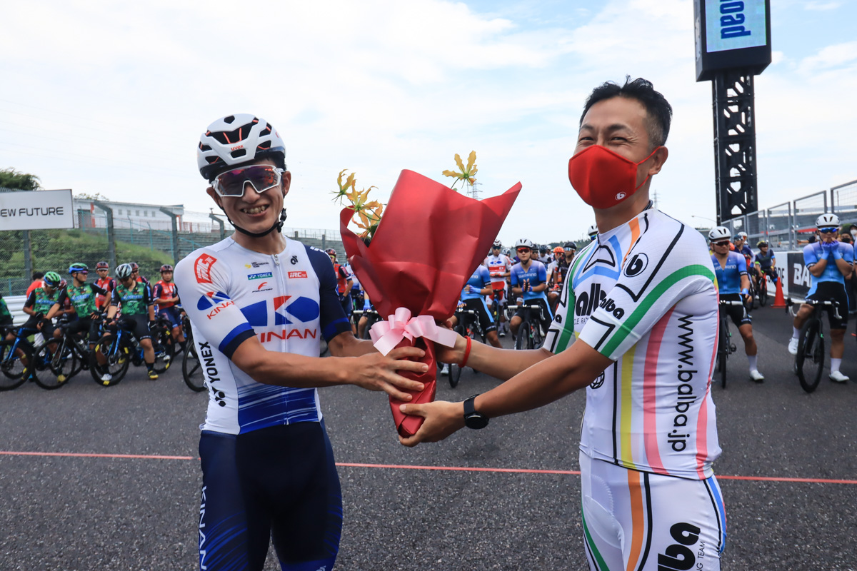 今季限りで引退する中島康晴(キナンレーシングチーム)に井上和郎が花束を手渡す