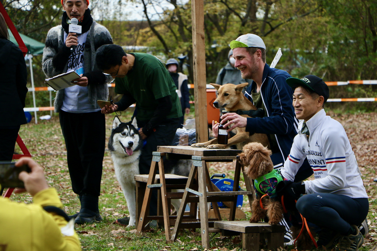カニクロス(犬とランニンング)の表彰式。優勝賞品のビールには一切の興味を示さない優勝犬